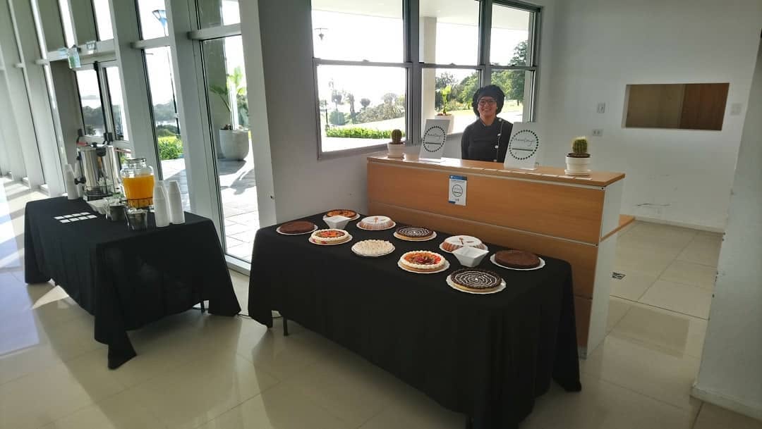 Estación de coffee break con termos, jugos y frutas