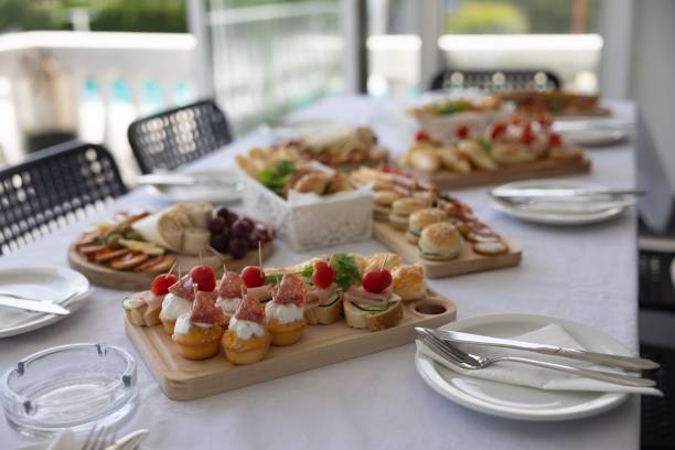 Mesa de lunch buffet con sándwiches, bocados y platos fríos